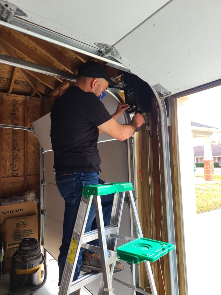 Technician installing a garage door opener in Houston